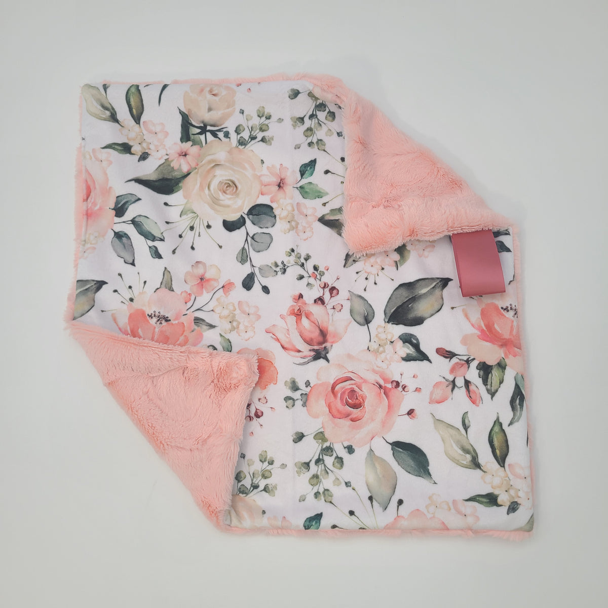 Peach floral lovey with shell hide backing
